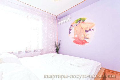 Выполненная в нежных сиреневых тонах спальня с изящным рисунком на стене